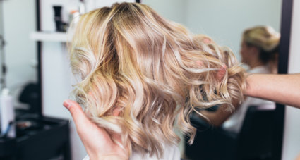 Woman with short, blonde and curled hair extensions